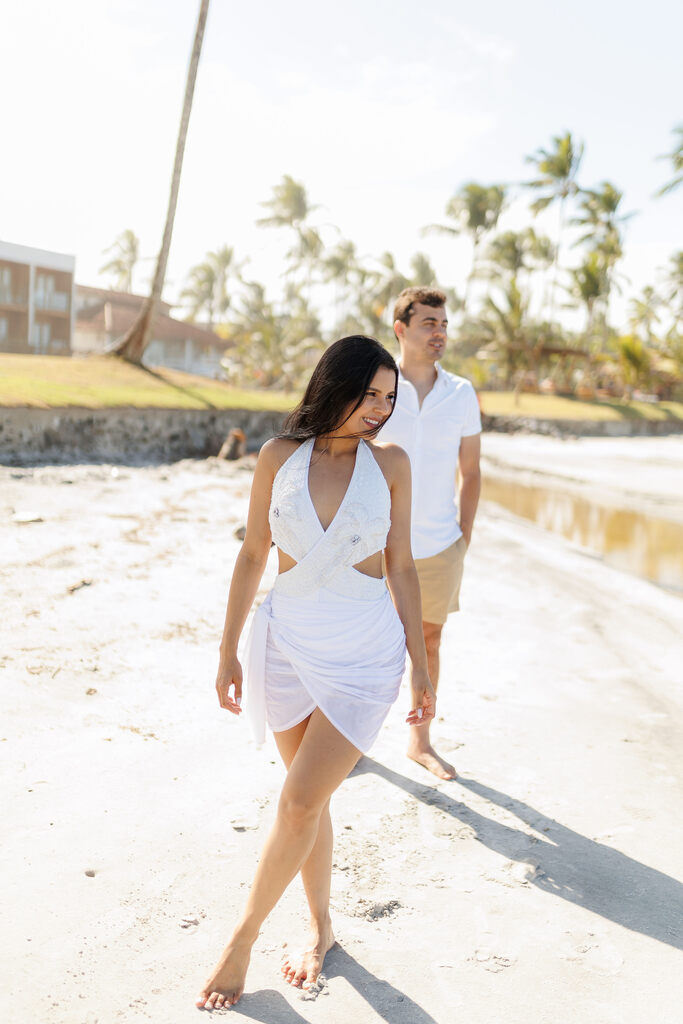 casal andando de mãos dadas na praia