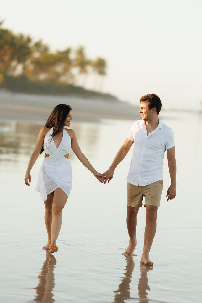 casal andando de mãos dadas na praia