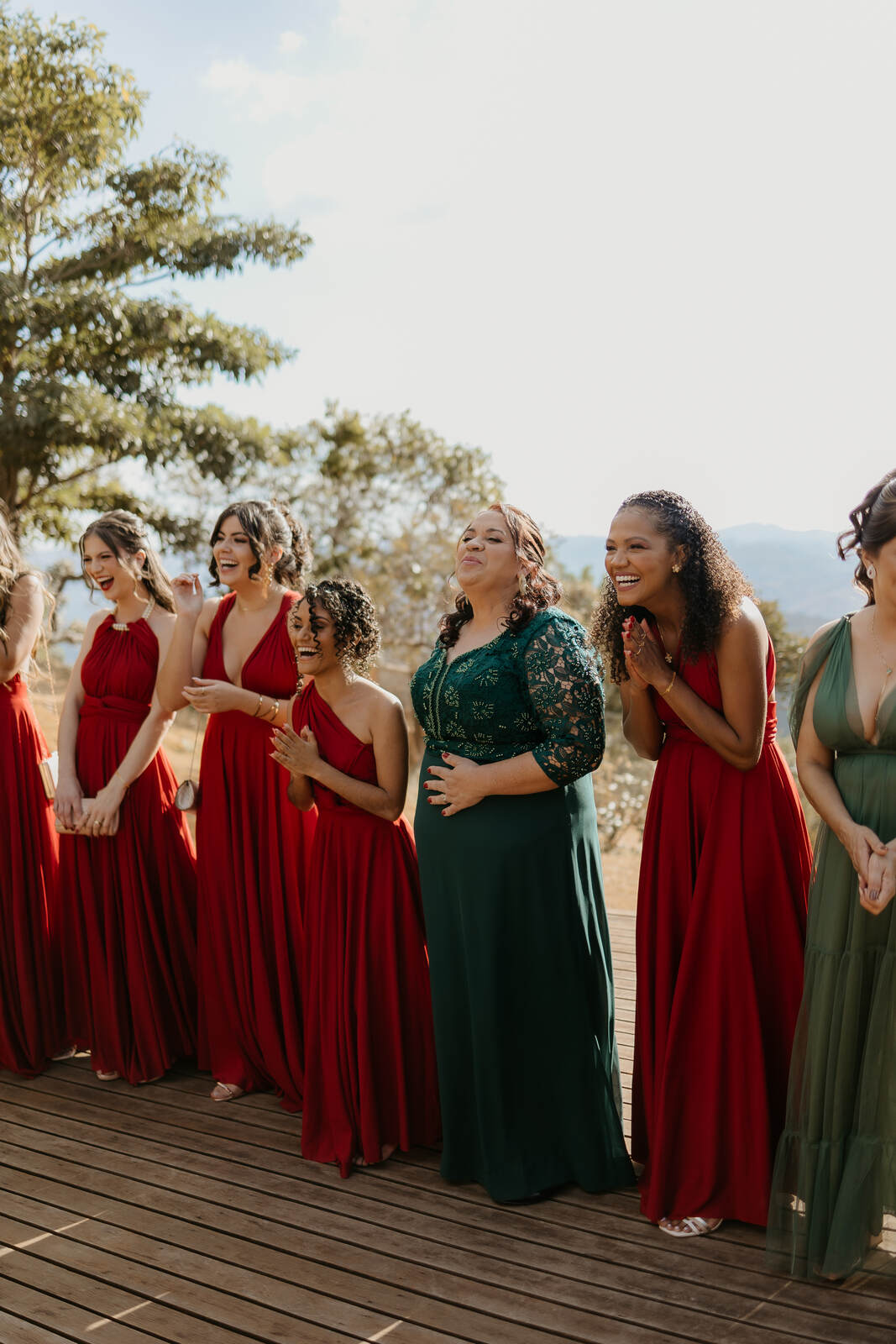 madrinhas de vestido vermelho e mãe com vestido verde