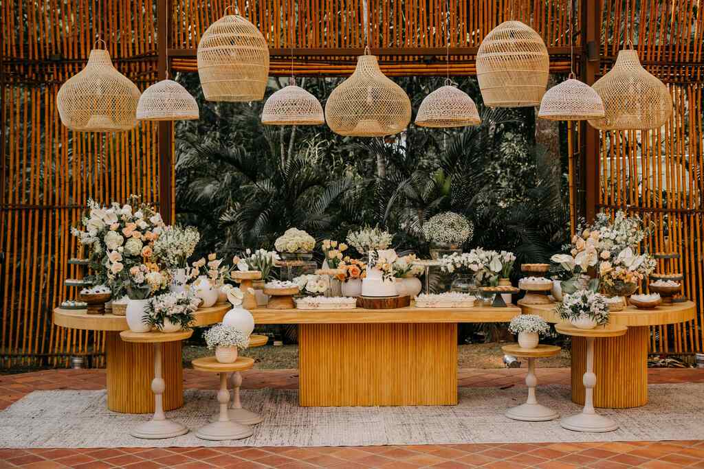 mesa do bolo e doces de casamento em tons de branco no estilo boho