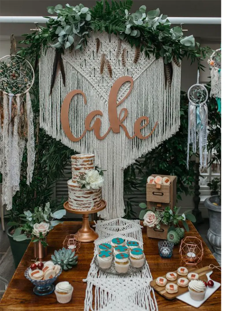 mesa de chá de panela boho com macramê e painel escrito cake