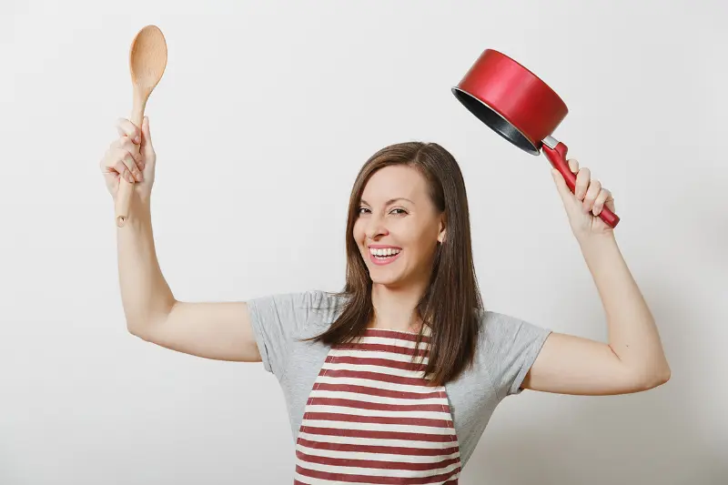 mulher segurando colher e panela