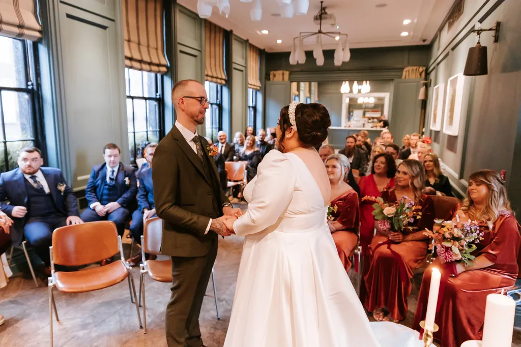 Casal no altar, de frente um para o outro de mãos dadas