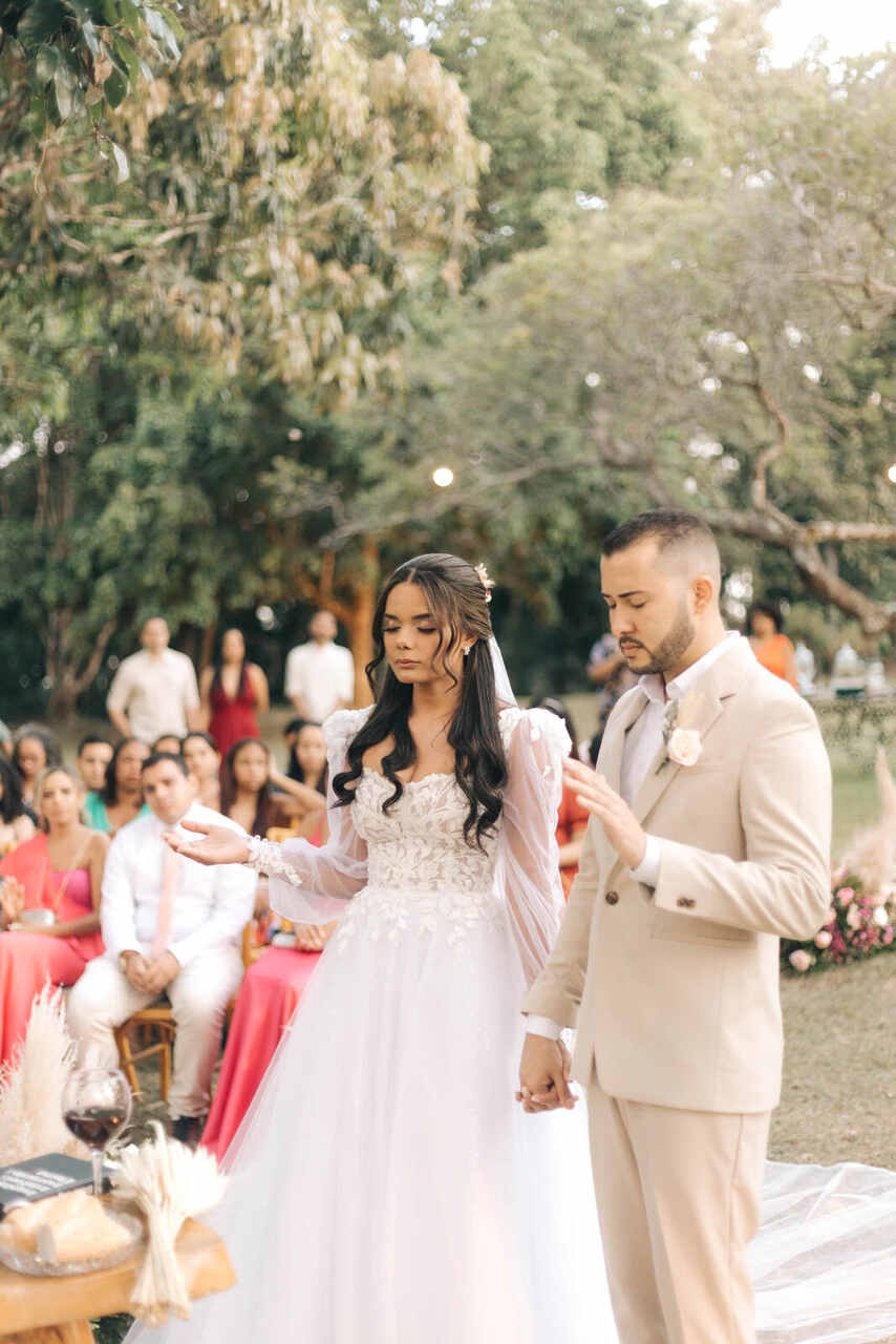 Casal no altar orando com as mãos levantadas