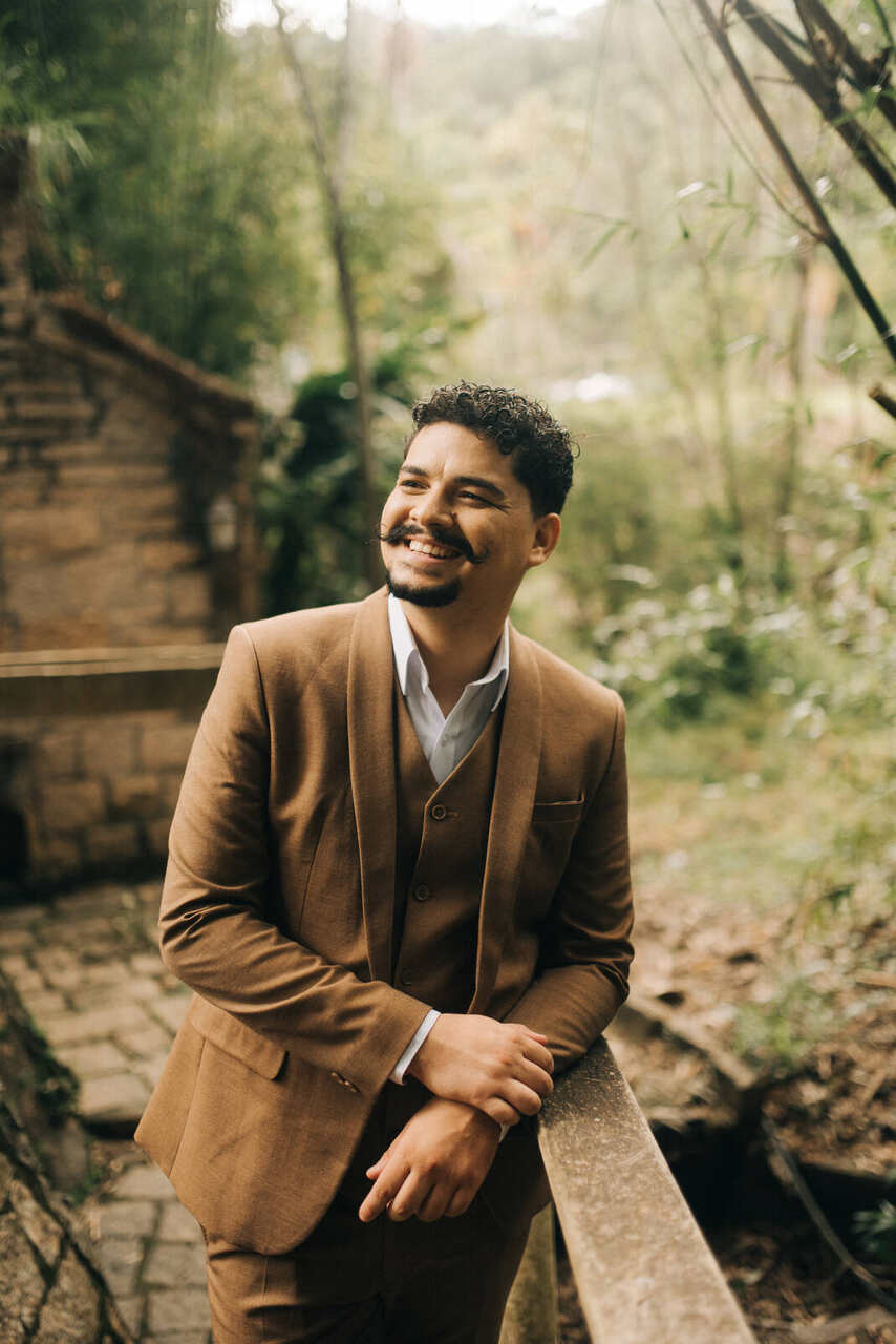 Noivo sorrindo com terno e colete bege, sem gravata