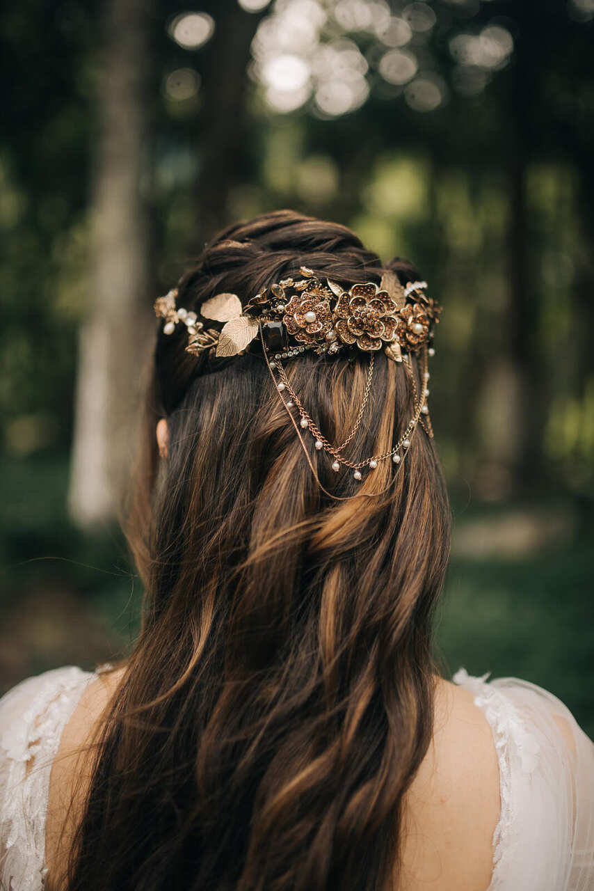 Noiva de costas. Foto focando no cabelo com um arranjo de metal na cabeça