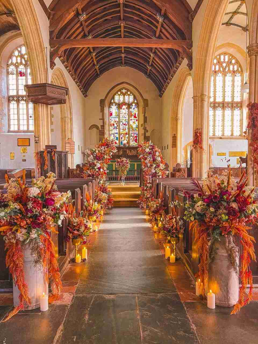 Igreja com decoração inspirada no outono, com arranjos de folhas secas, flores e velas