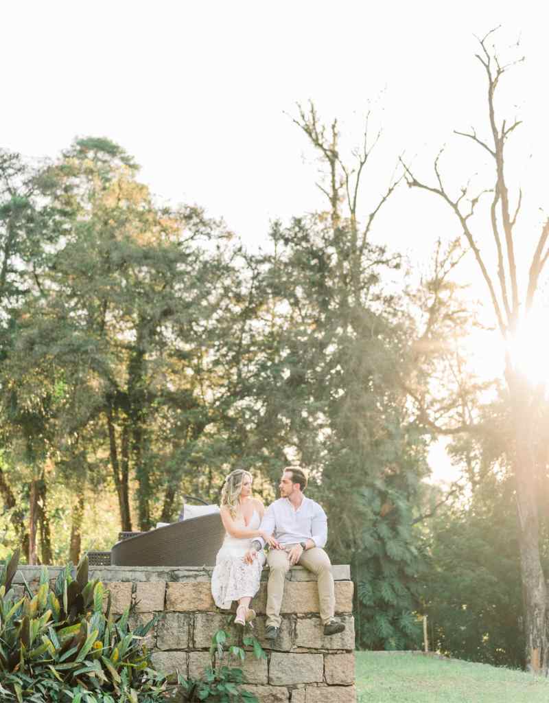 casal sentado em muro na Casa do Campo em ensaio pré-wedding