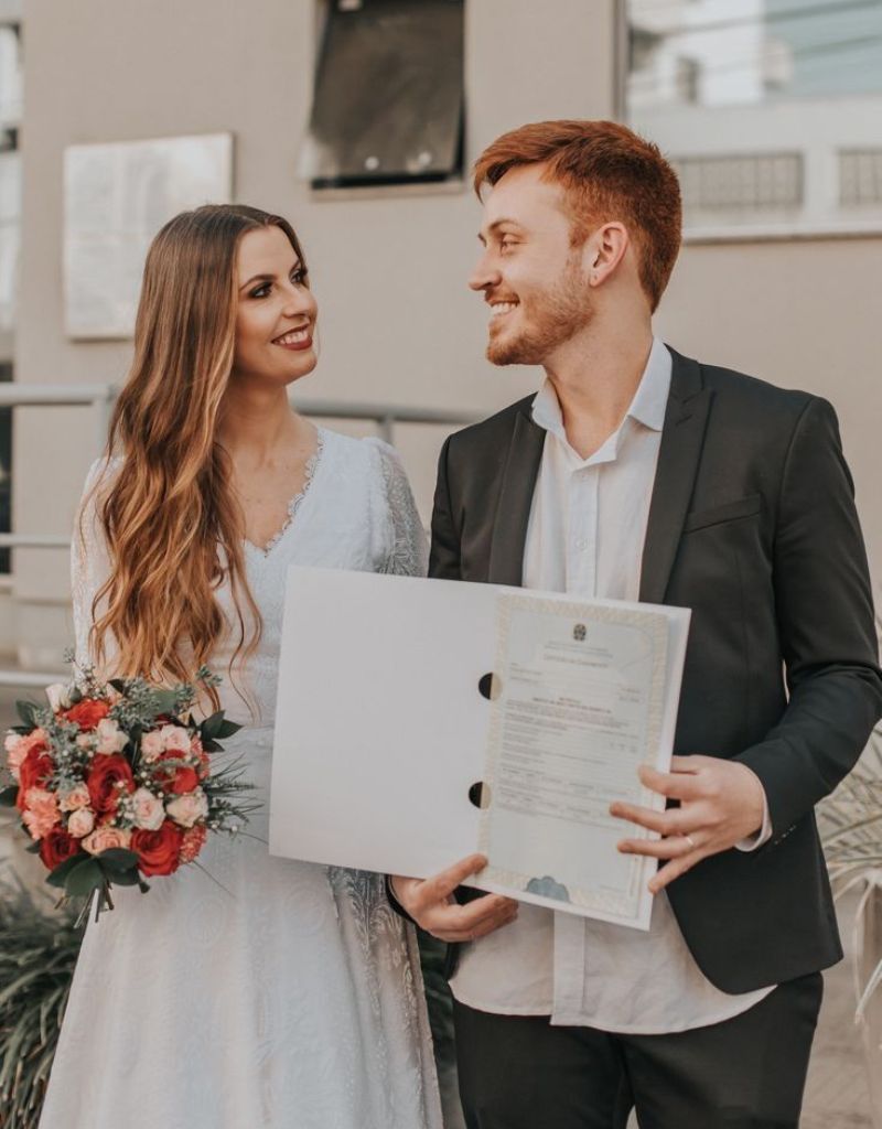 casal segurando certidão de casamento