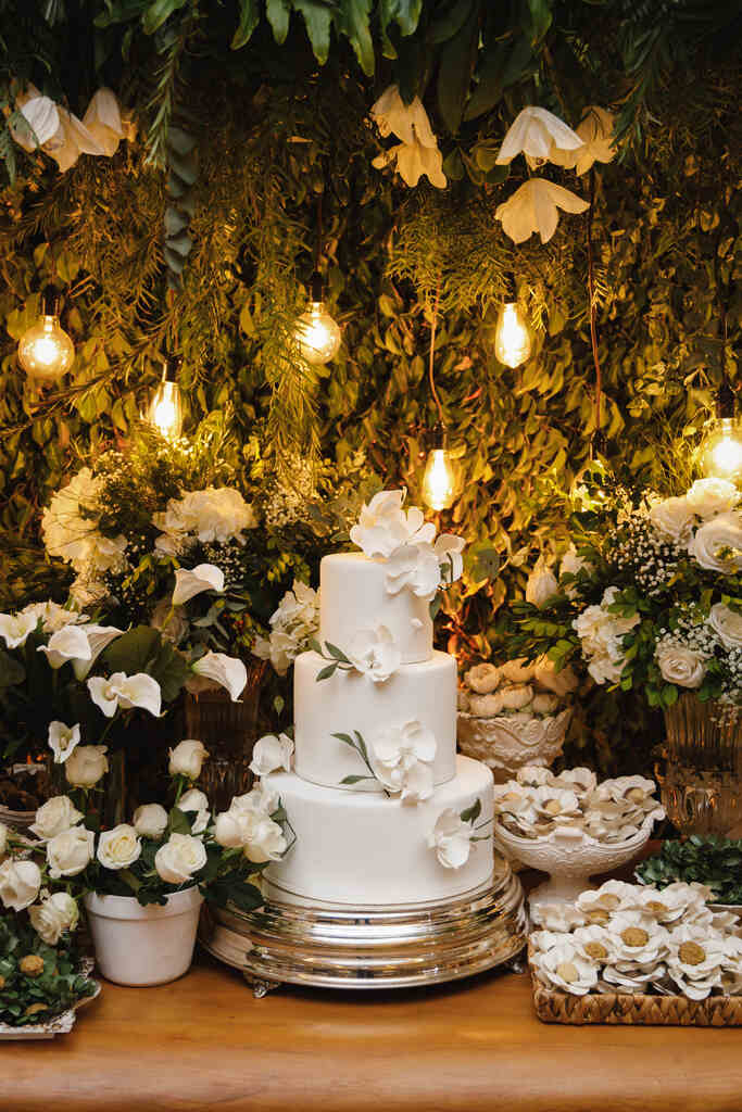 mesa com bolo de casamento com flores brancas