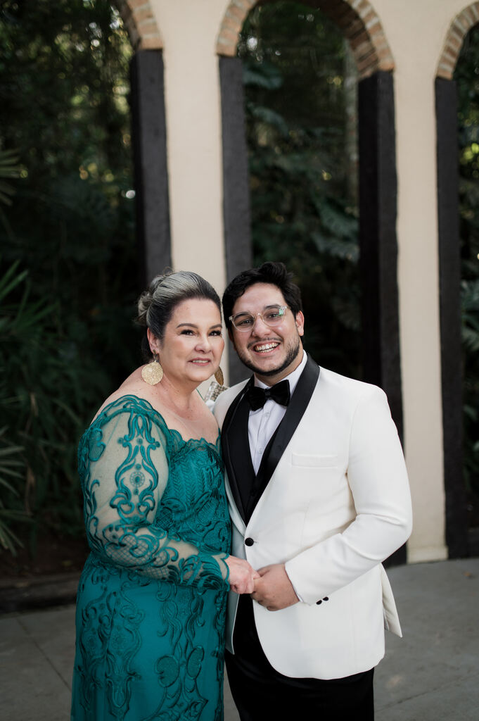 noivo de smoking branco com a mãe de vestido verde