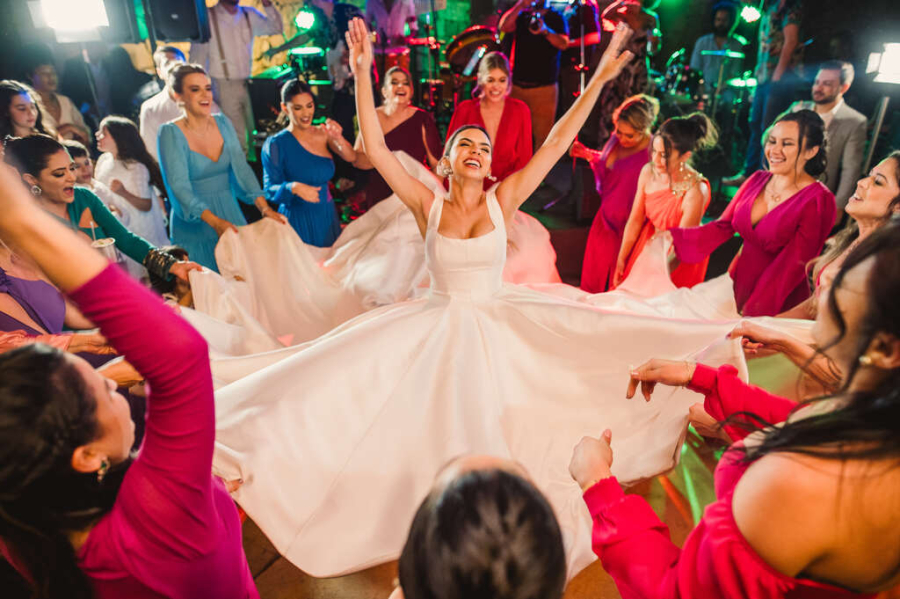 convidadas segurando vestido de noiva em dança 