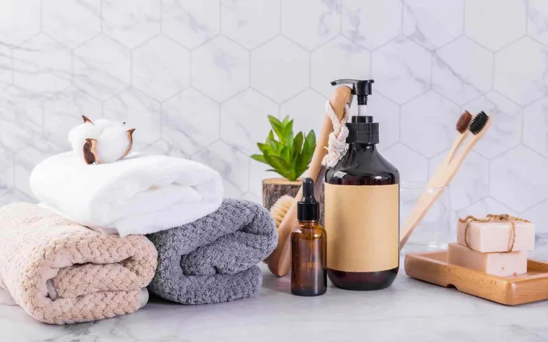 enxoval de casamento para banheiro com toalha de rosto, sabonete liquido e sabonetes em cima da bancada