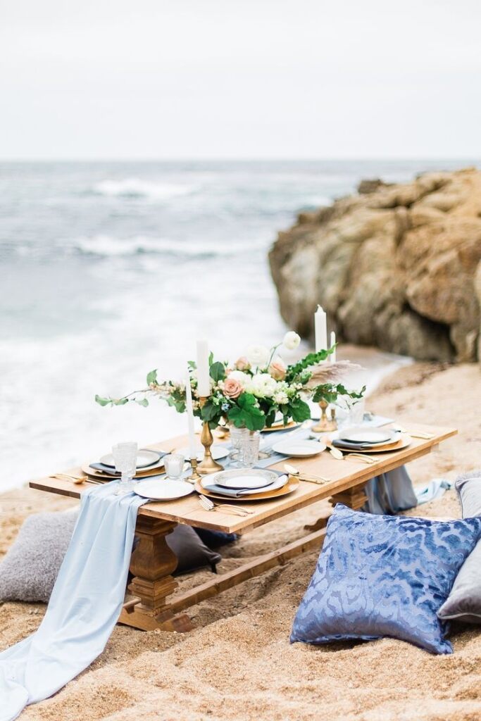 mesa com almofadas na areia da praia