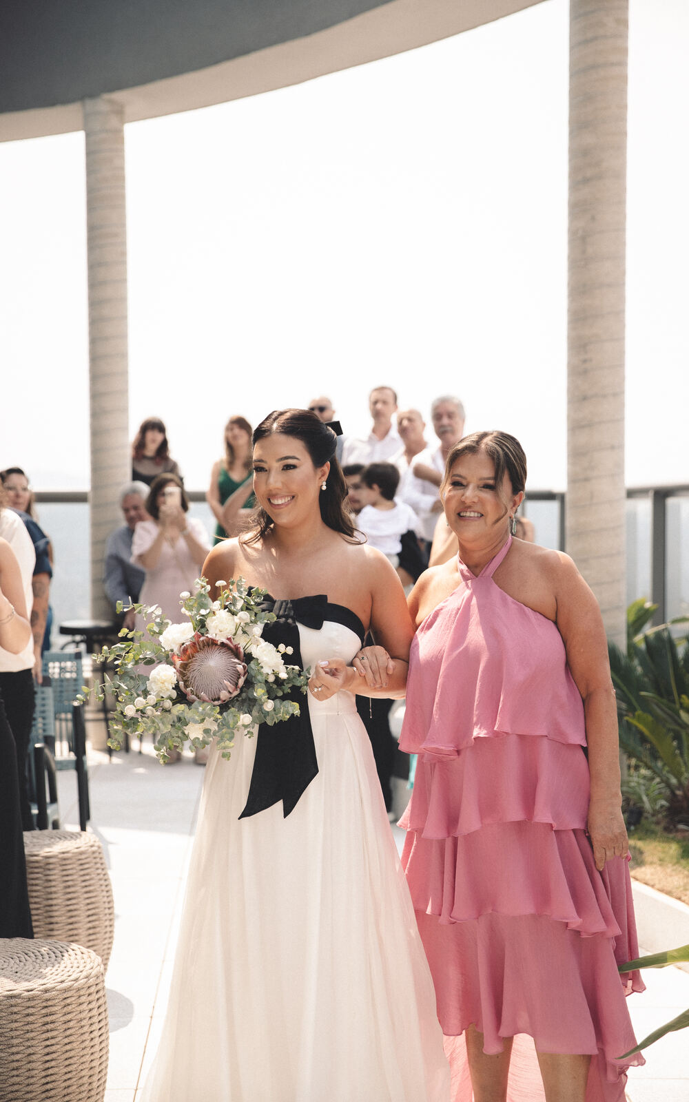 entrada da noiva ao lado da mãe com vestido rosa