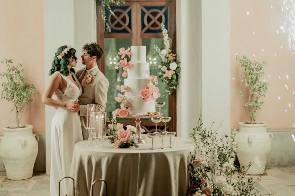 casal abraçado ao lado da mesa do bolo