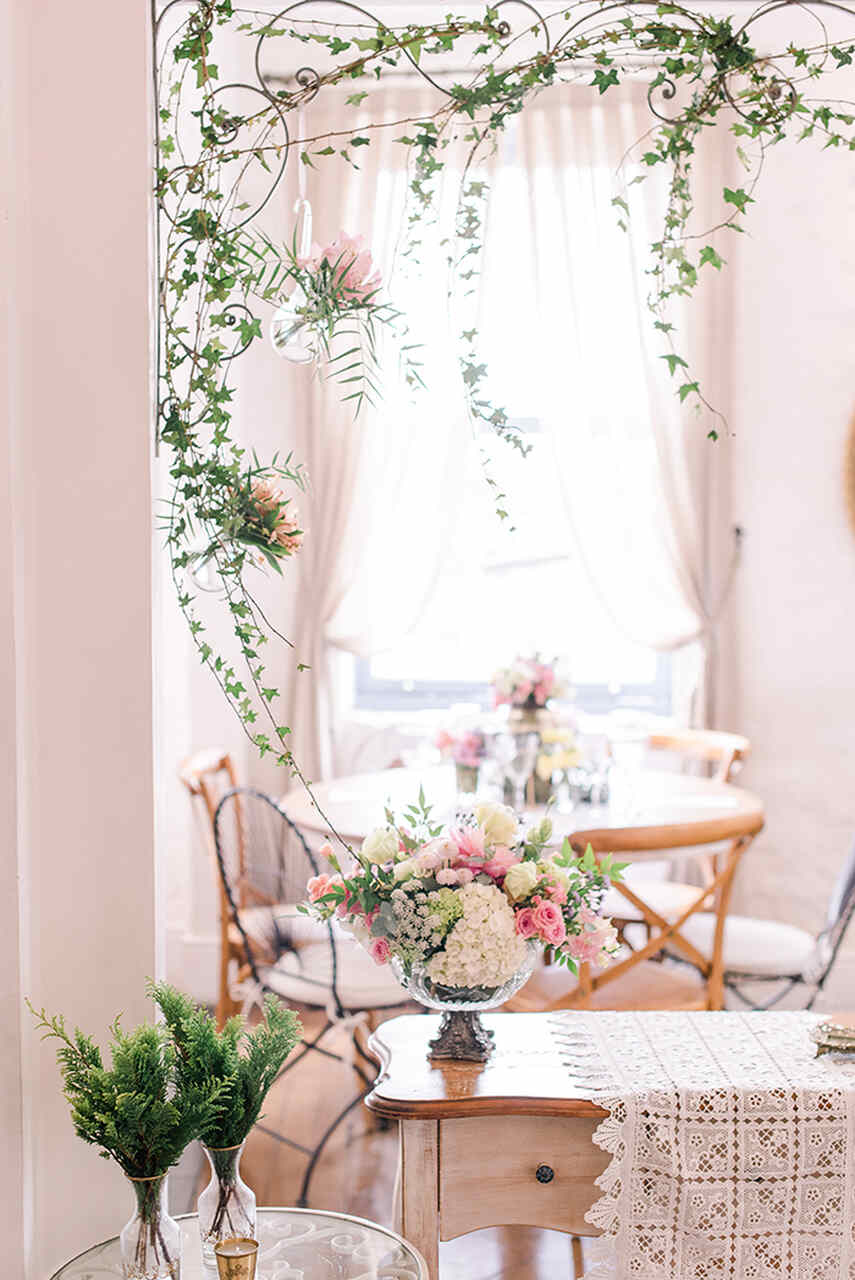 Um canto decorado com flores delicadas, luz natural e móveis de madeira clara