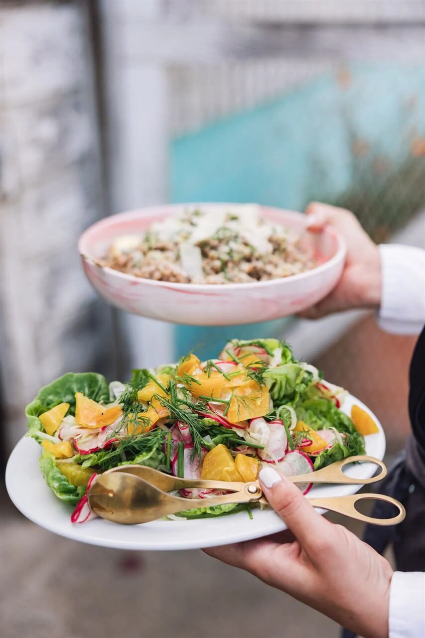 Prato com salada colorida e bowl com um grão preparado, servidos juntos.