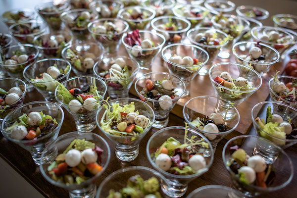 Taças individuais de salada com mussarela de búfala e vegetais frescos.