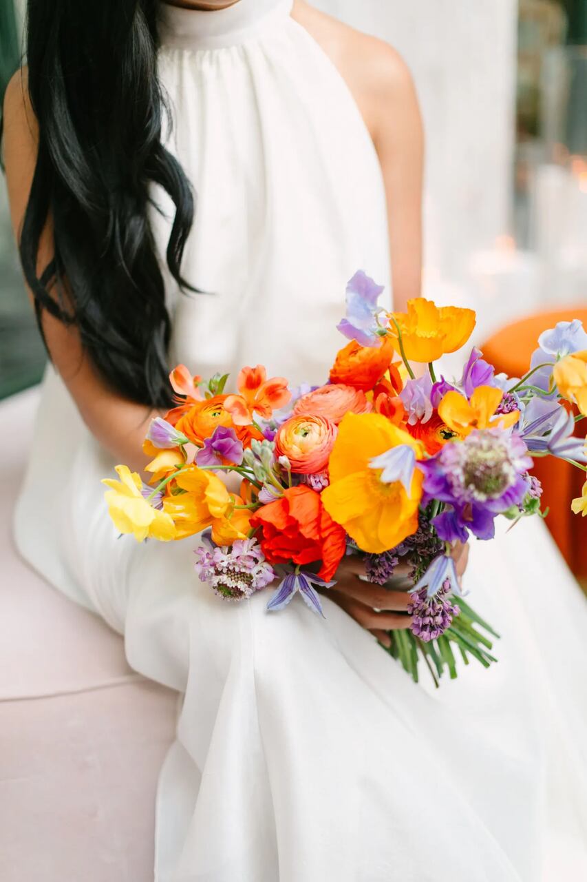 Buquê vibrante com flores em tons de laranja, amarelo e roxo