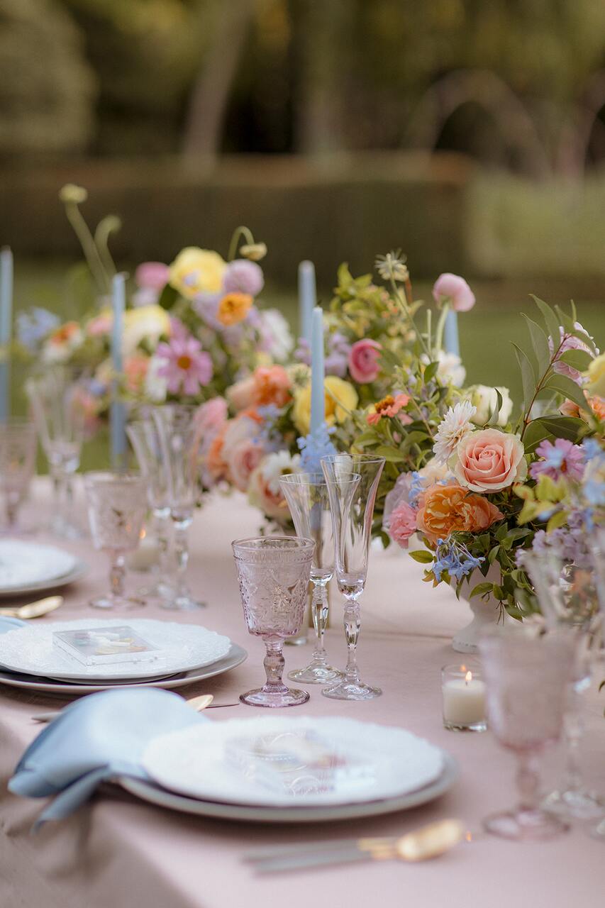 Uma mesa encantadora com arranjos florais coloridos e detalhes de vidro