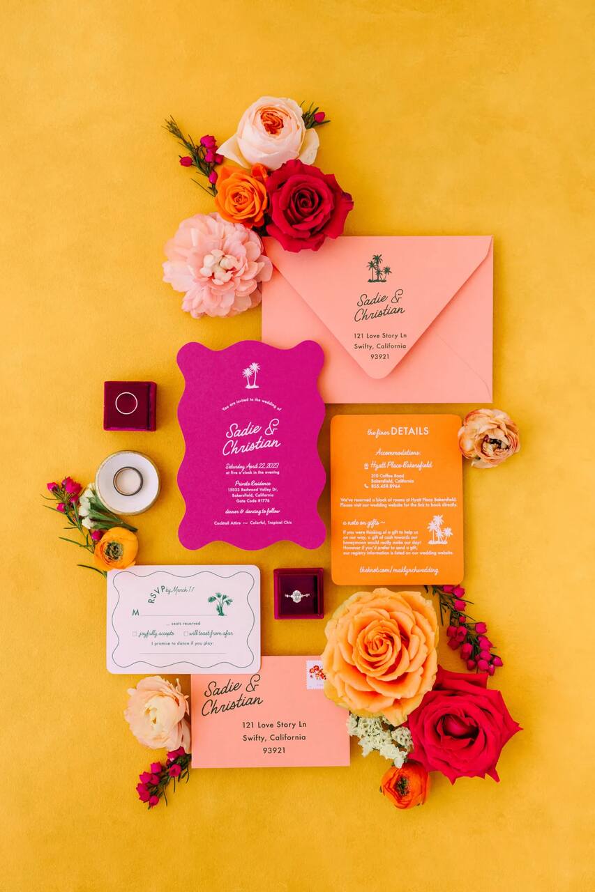 Conjunto de papelaria de casamento vibrante em amarelo, laranja e rosa, decorado com flores coloridas e joias delicadas