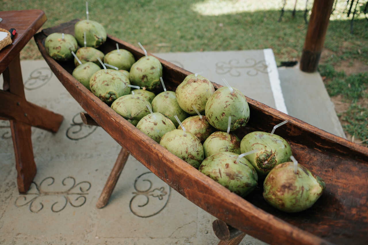 Barco rústico usado como recipiente para servir cocos verdes com canudos.