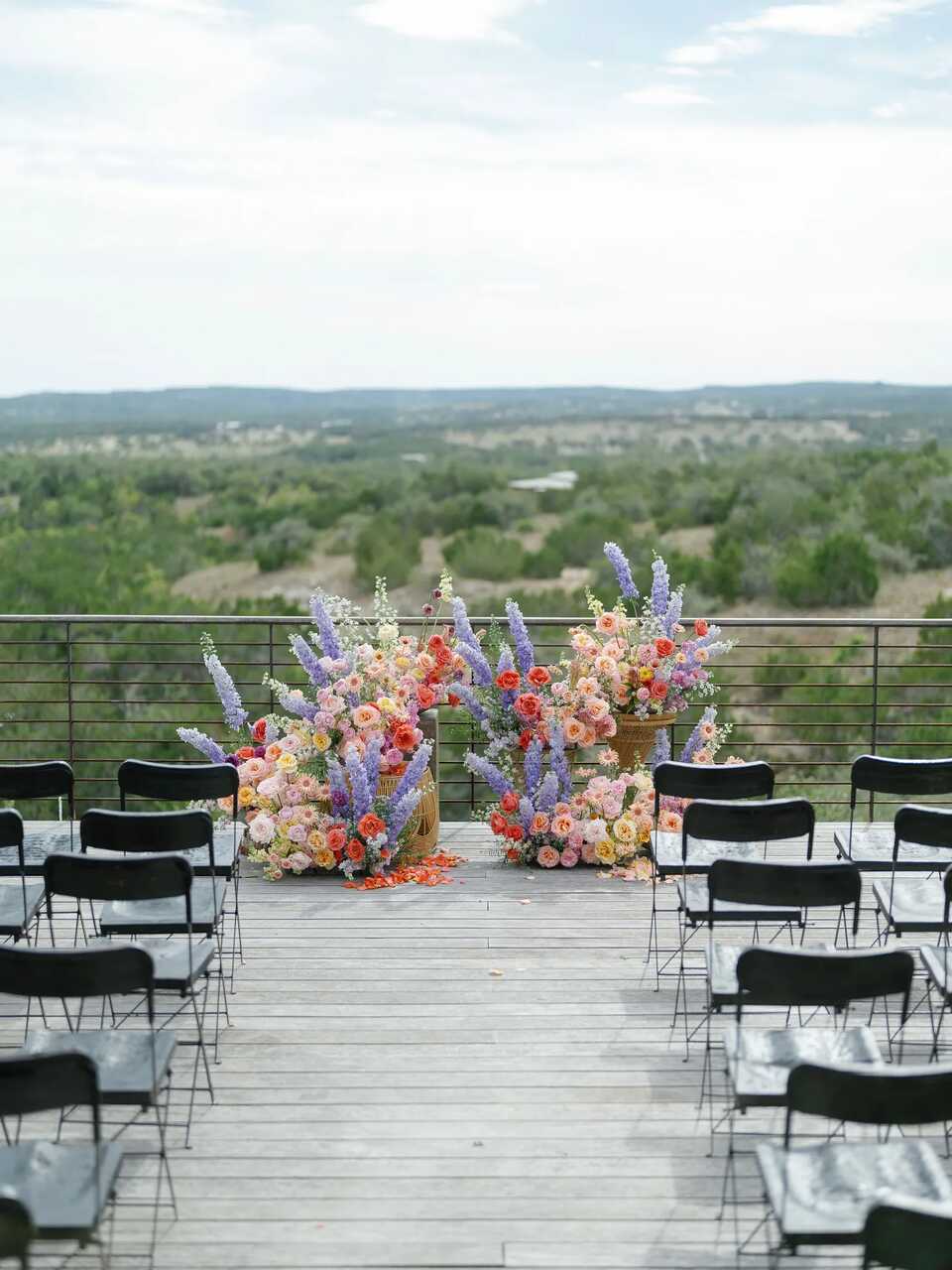 Um altar ao ar livre com vista panorâmica, adornado com flores vibrantes em cestos