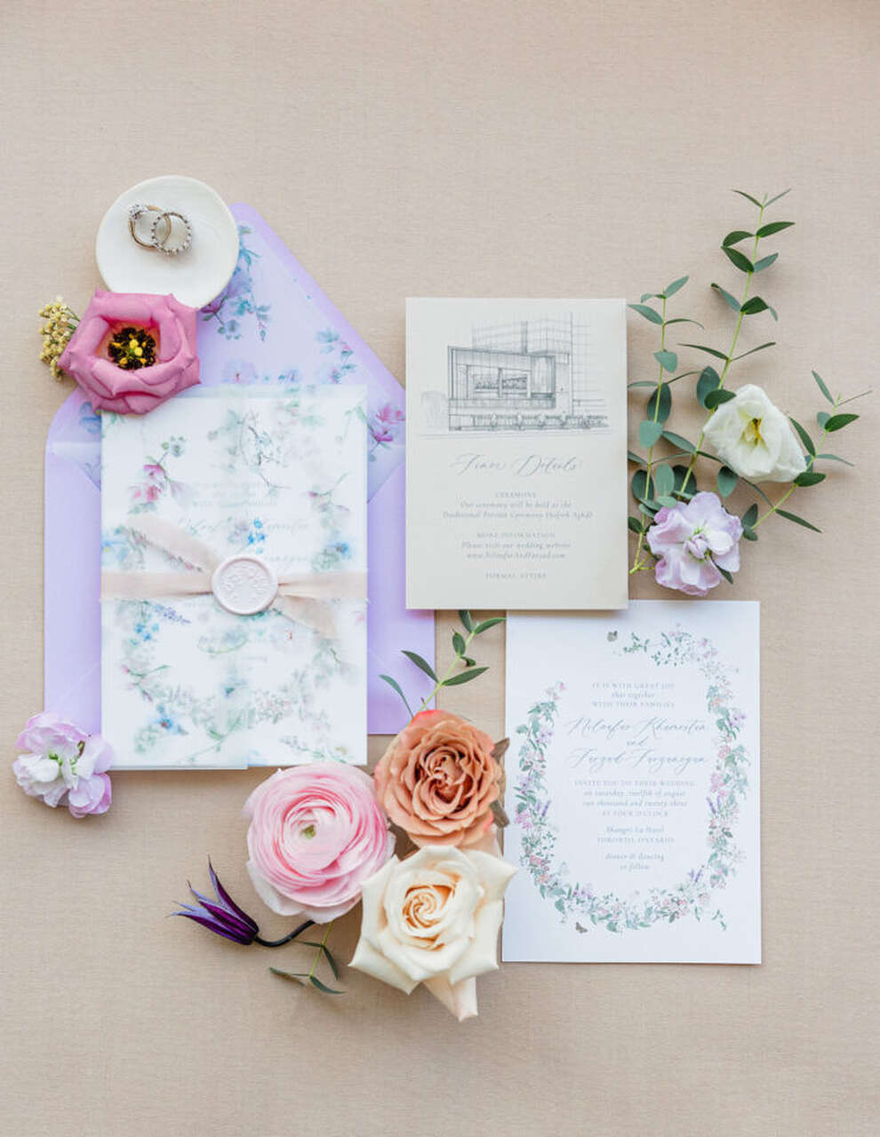 Composição de convites de casamento em tons pastel com flores frescas