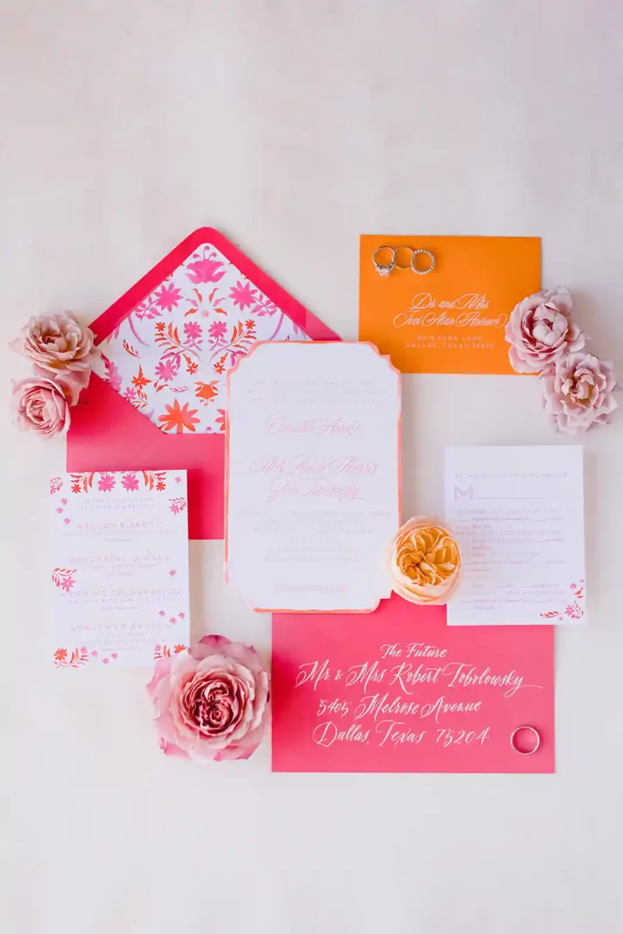 Conjunto de papelaria de casamento com tons de rosa, laranja e branco, incluindo convites e envelopes, decorados com rosas delicadas