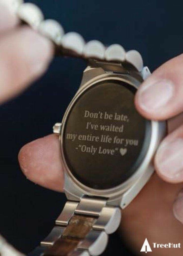 Close de um relógio de pulso personalizado com uma mensagem gravada na parte traseira: "Don't be late, I've waited my entire life for you. - 'Only Love' ♥". 