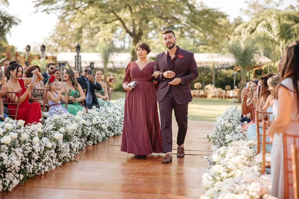 entrada do noivo com terno marsala ao lado da mãe com vestido marsala