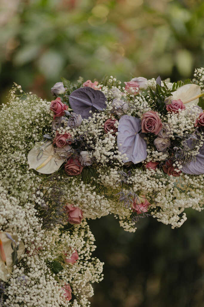 arranjo floral com flores brancas roxas e rosas