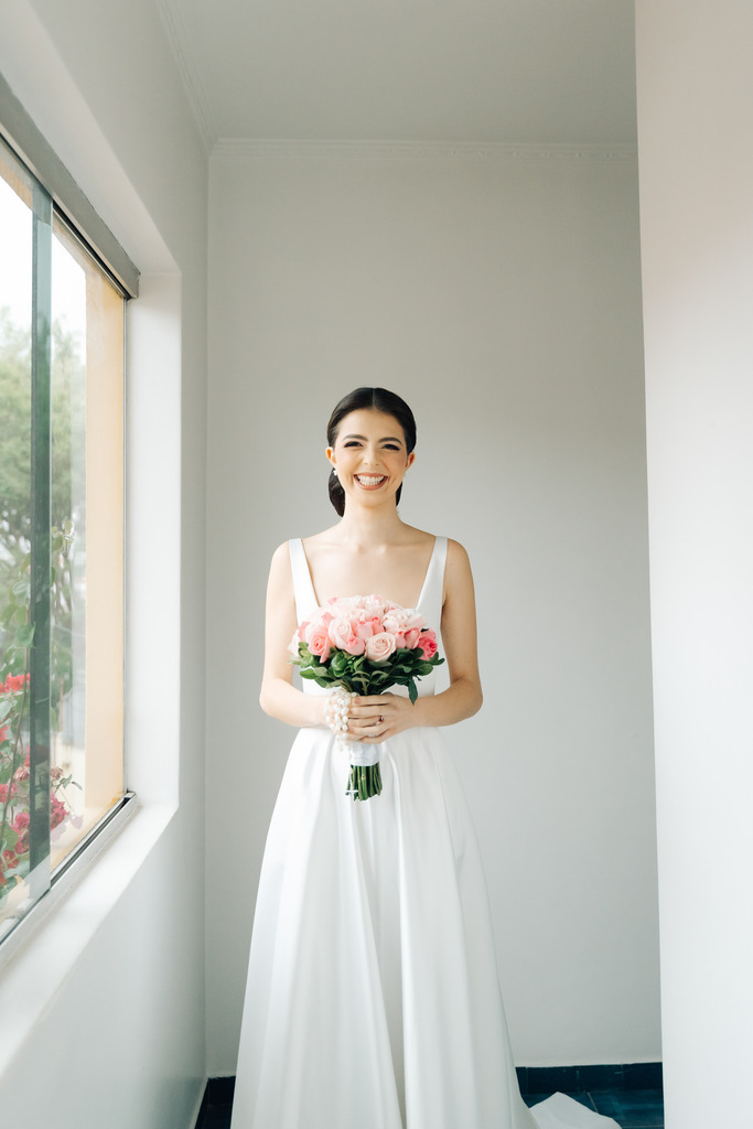 mulher com vestido de noiva com buquê rosa