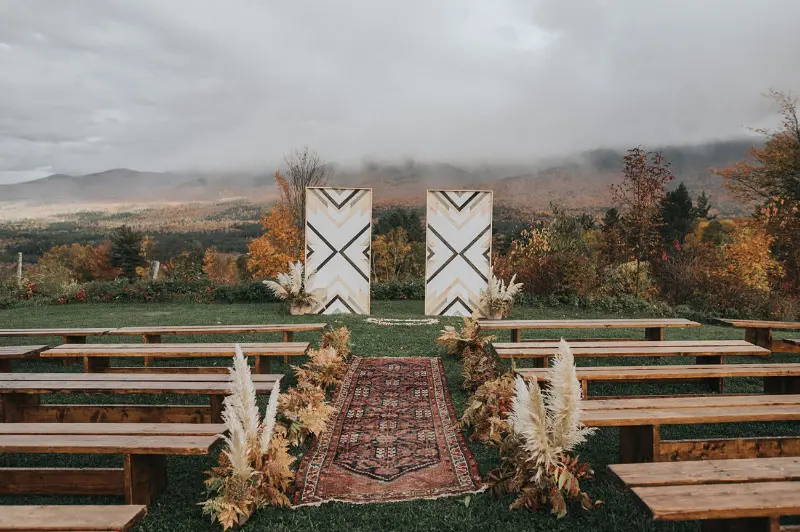 cerimônia ao ar livre com tapete no caminho dos noivos e banco de madeira