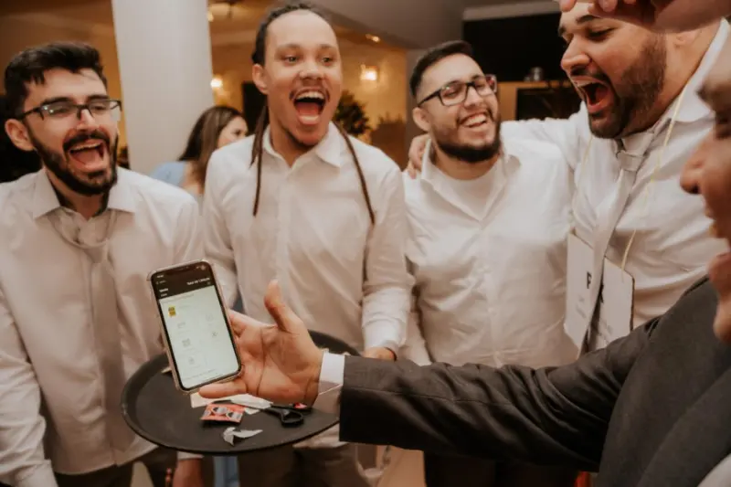 convidados comemorando o corte da gravata