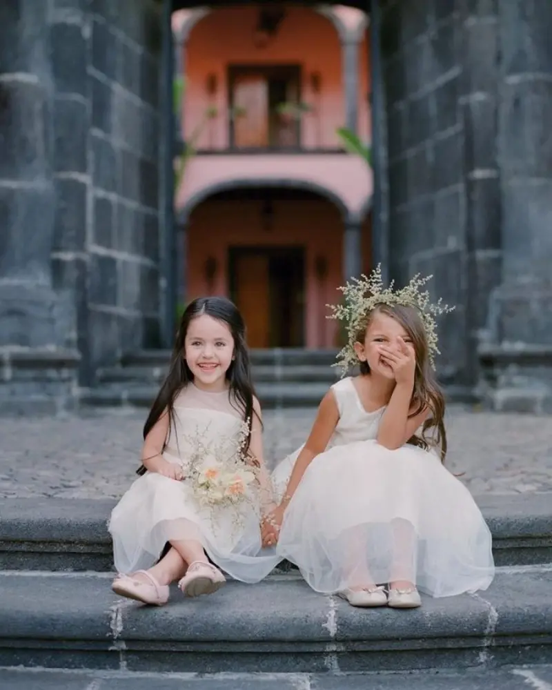  duas daminha de honra sentada na escada sorrindo