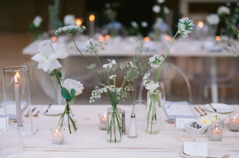 decoração de mesa minimalista para casamento com vidros e flores