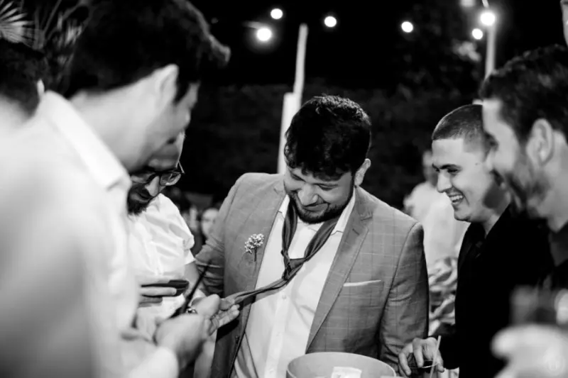 gravata do noivo sendo cortada