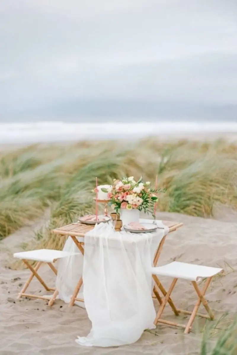 mesa dos noivos ao ar livre com arranjo de flores no vaso