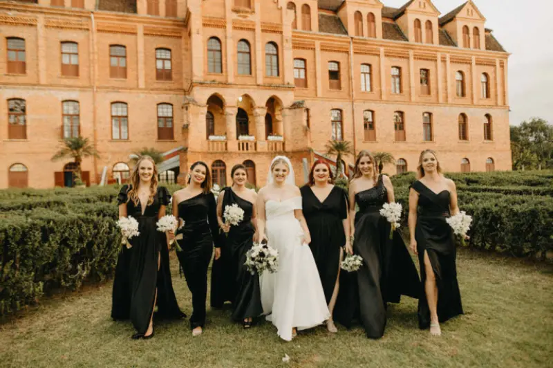 noiva caminhando com madrinhas de vestido preto