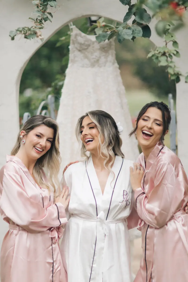 noiva com robe branco ao lado de madrinhas