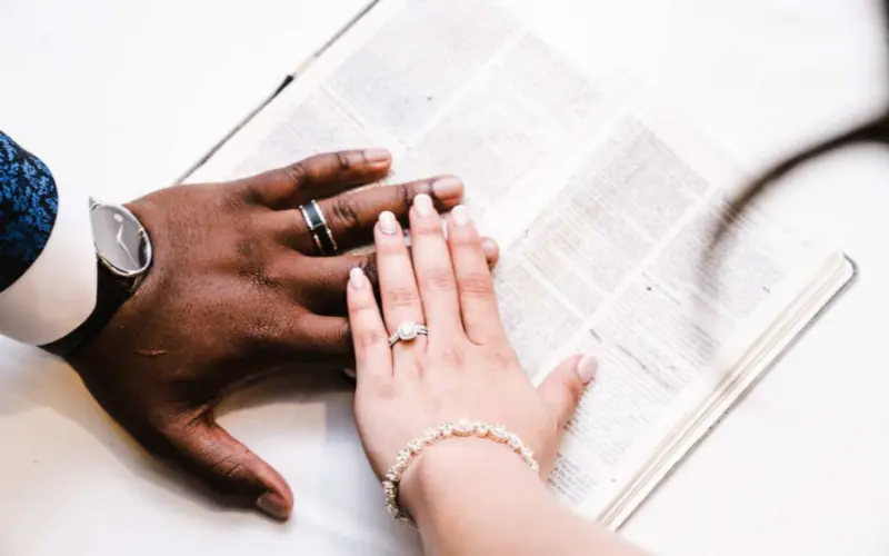 noivos com mão na bíblia durante a cerimônia evangélica