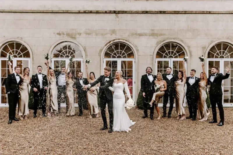 noivos estourando champagne com padrinhos