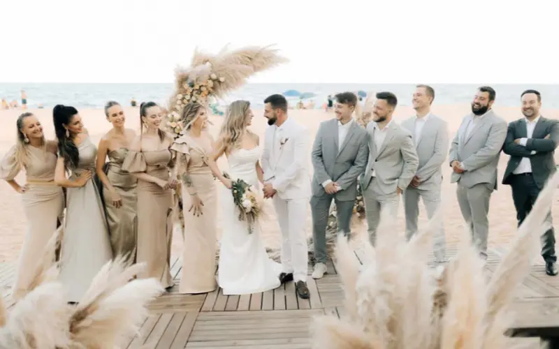 padrinhos de casamento na praia ao lado dos noivos na saída da cerimônia