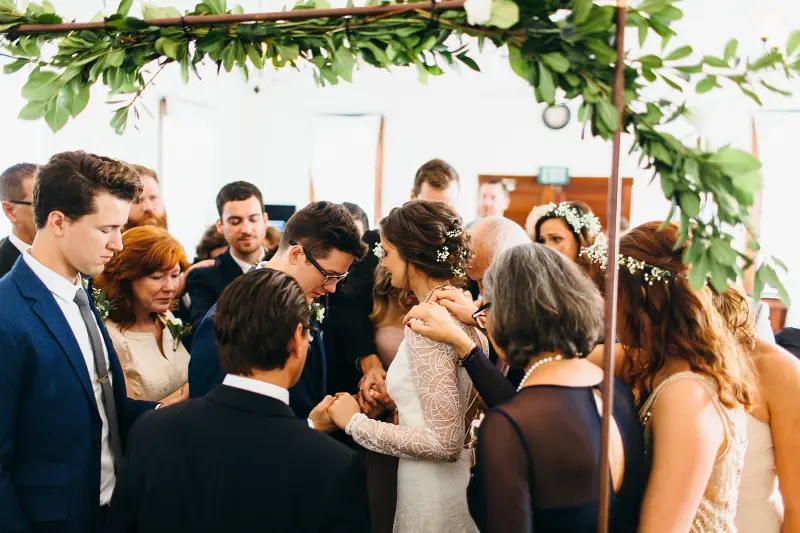 padrinhos de casamento orando com noivos