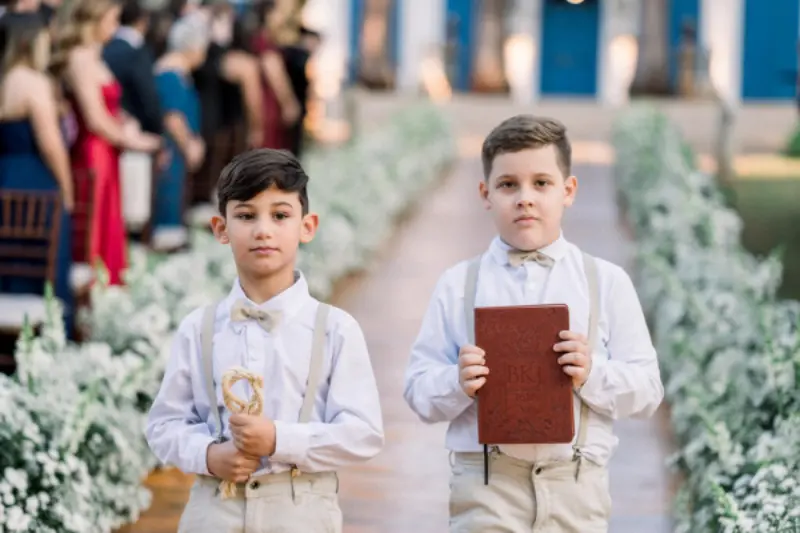 pajem de casamento segurando a bíblia e outro segurando corda