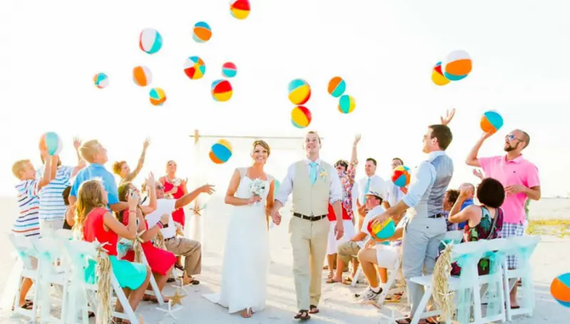 saída dos noivos com bolas sendo jogadas na praia