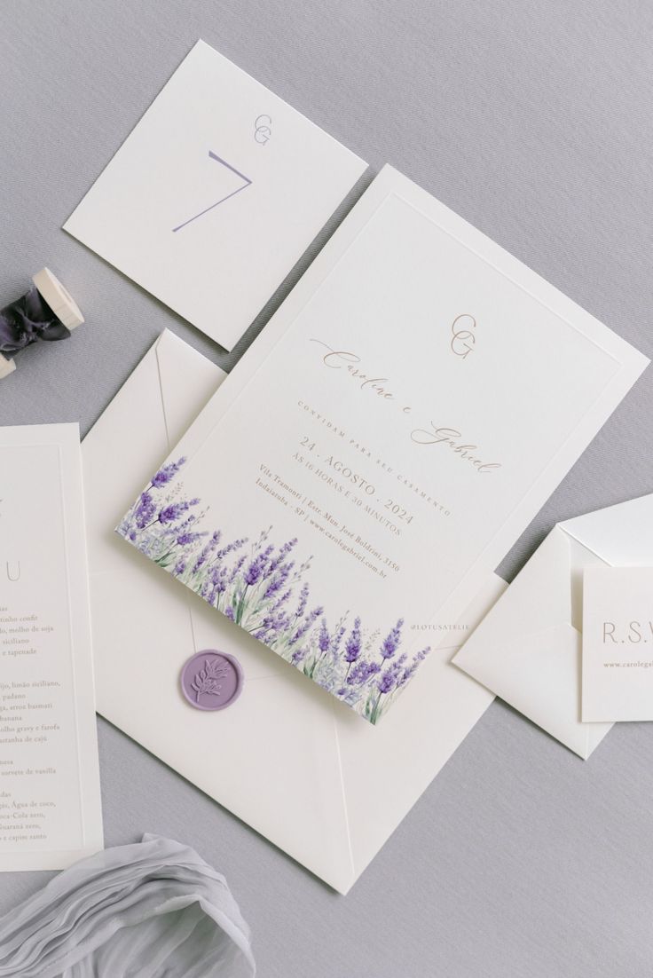 Convite de casamento elegante com flores de lavanda, selado com lacre roxo, acompanhado de cartões RSVP e detalhes em tons suaves de lilás.