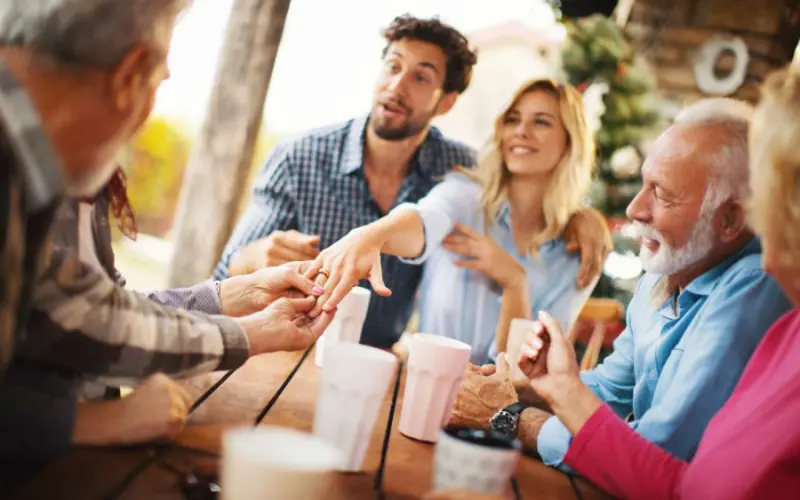 reunião de amigos animada, onde os noivos sendo presenteados. E a aliança está sendo mostrada pela noiva